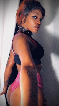 a black woman in a pink bikini posing for a photo